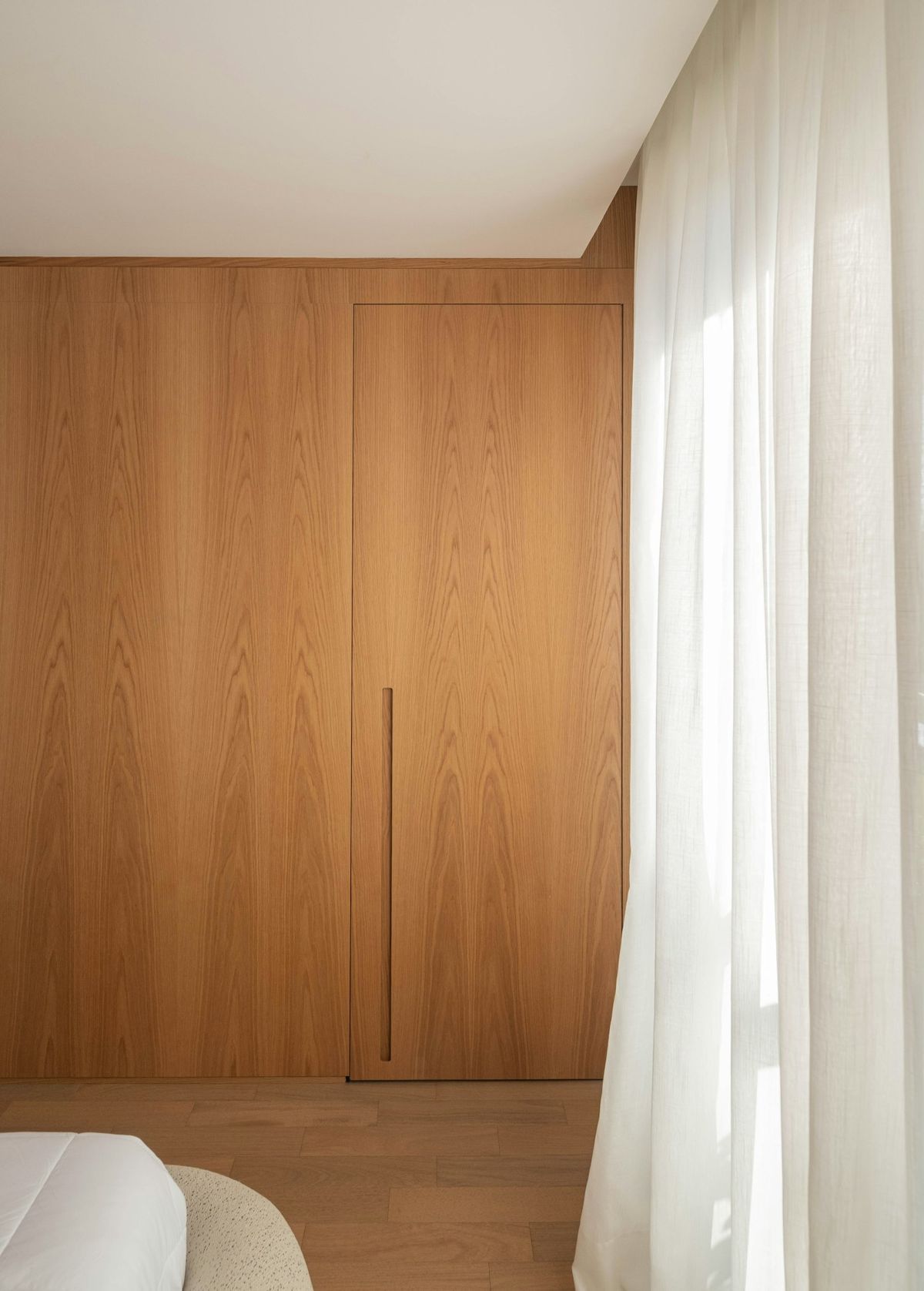 Warm oak wall and linen curtain in soft daylight