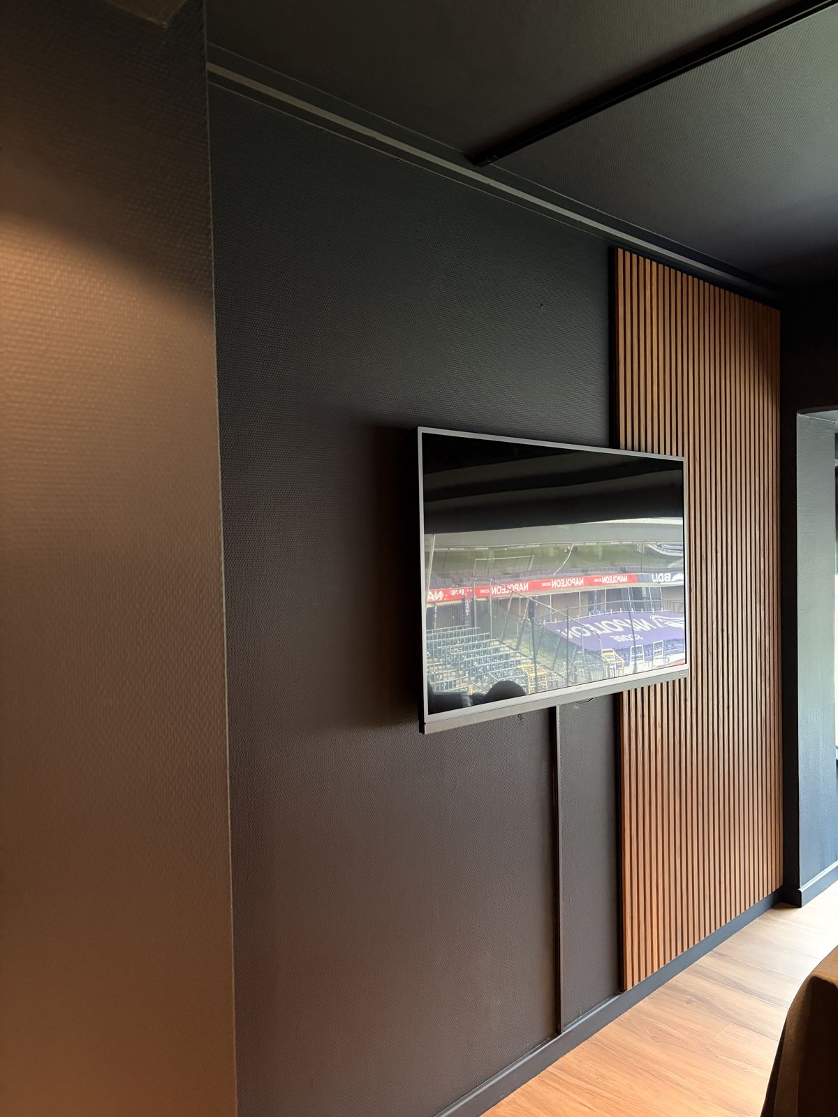 Midnight blue wall with wood acoustic slats and screen